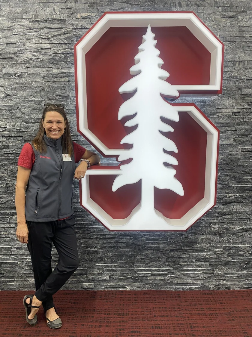 Patty standing beside Stanford’s tree emblem